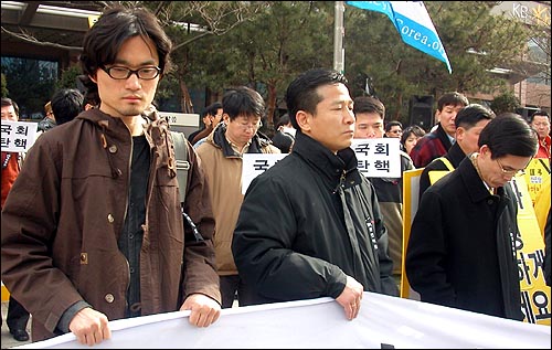 11일 오전 10시부터 여의도 국민은행 앞 인도에 모인 노 대통령 지지 시민들이 심각한 표정으로 기자회견 내용을 듣고 있다. 